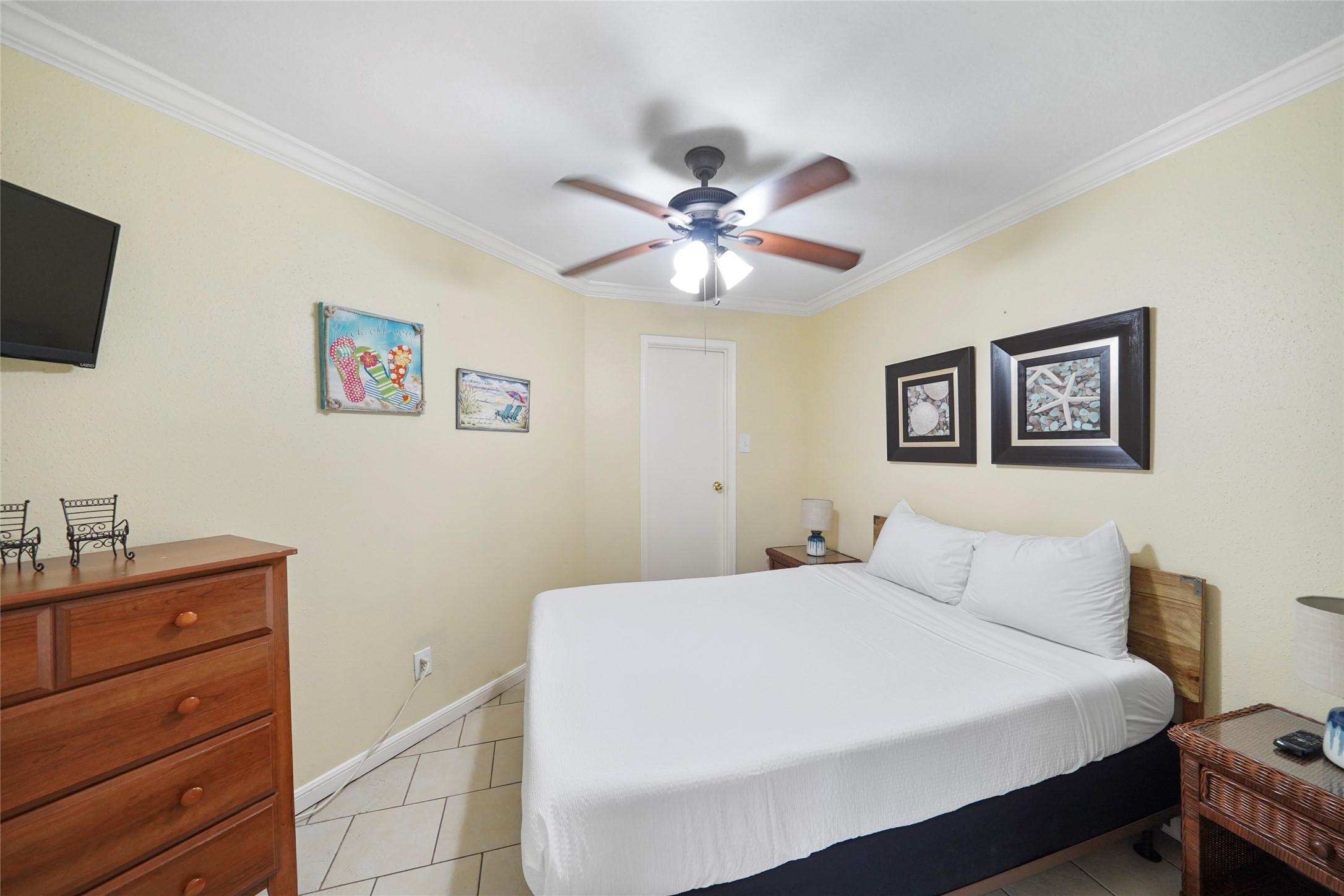 Image 2: Cozy bedroom with a ceiling fan, neutral walls, an