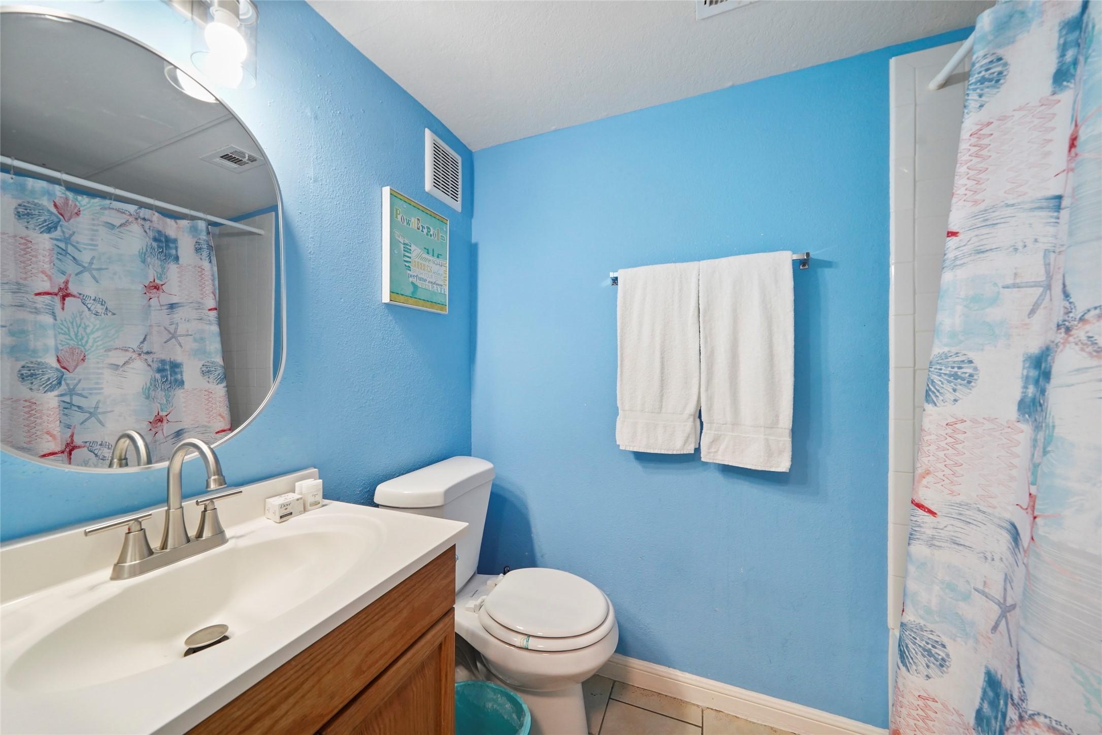 Image 3: This bathroom features bright blue walls, a white