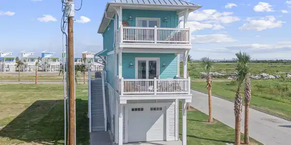 Image 3: Front exterior view featuring elevated beach home