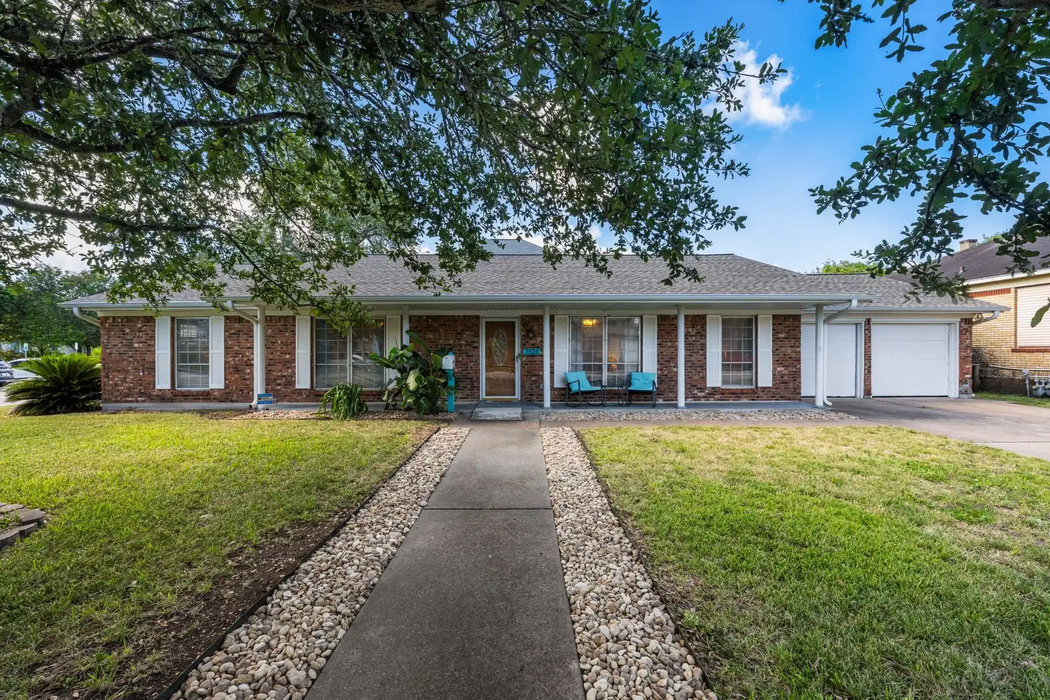 Image 1: Classic single-story brick exterior framed by matu