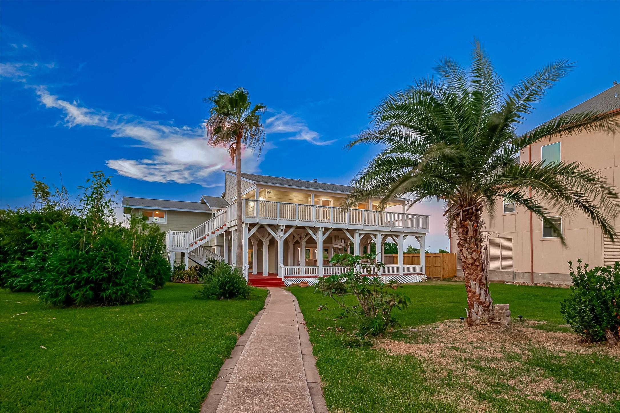 Image 2: Inviting approach framed by mature palms and lush