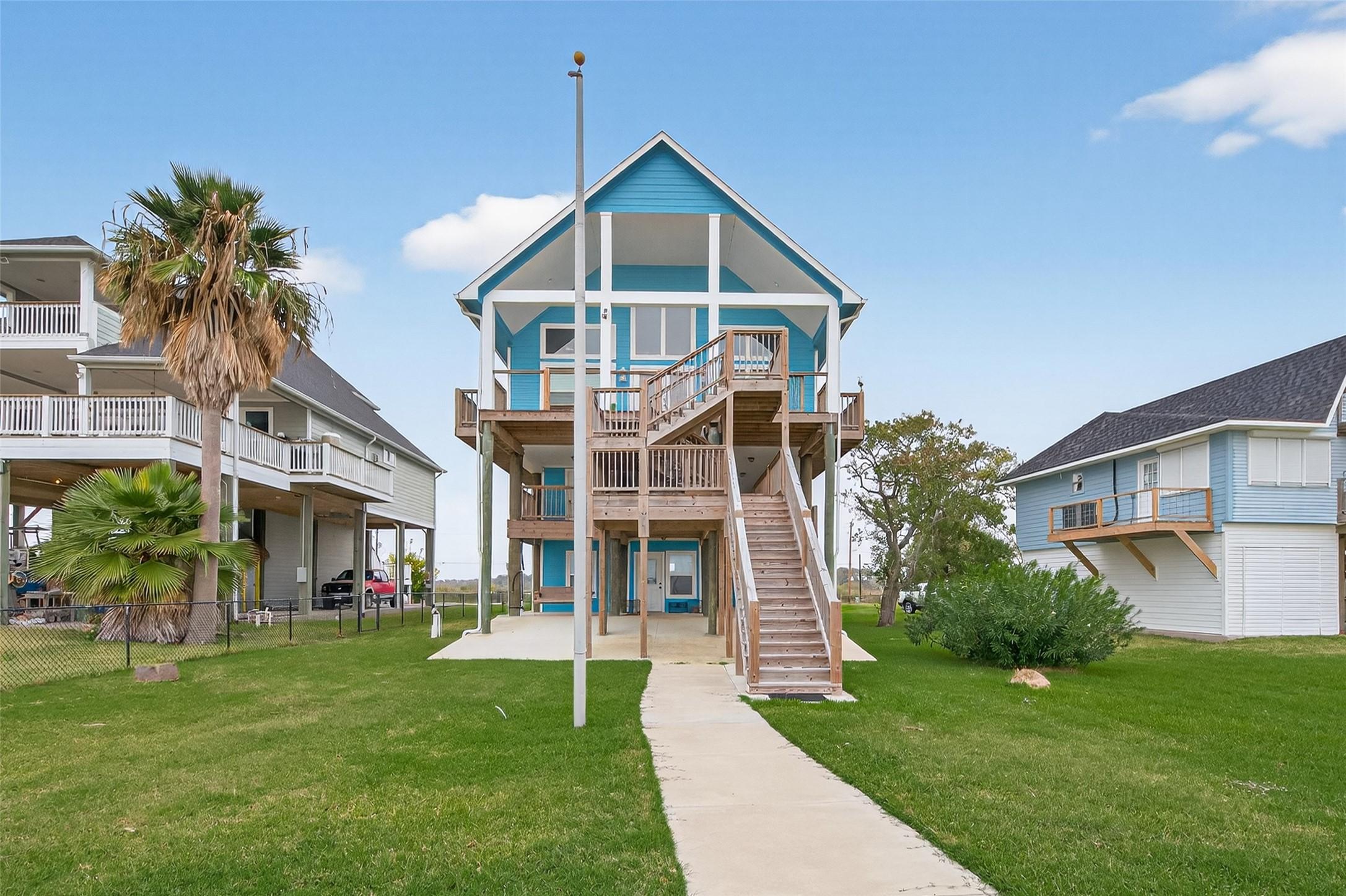 Image 4: Charming elevated beach house with a vibrant blue