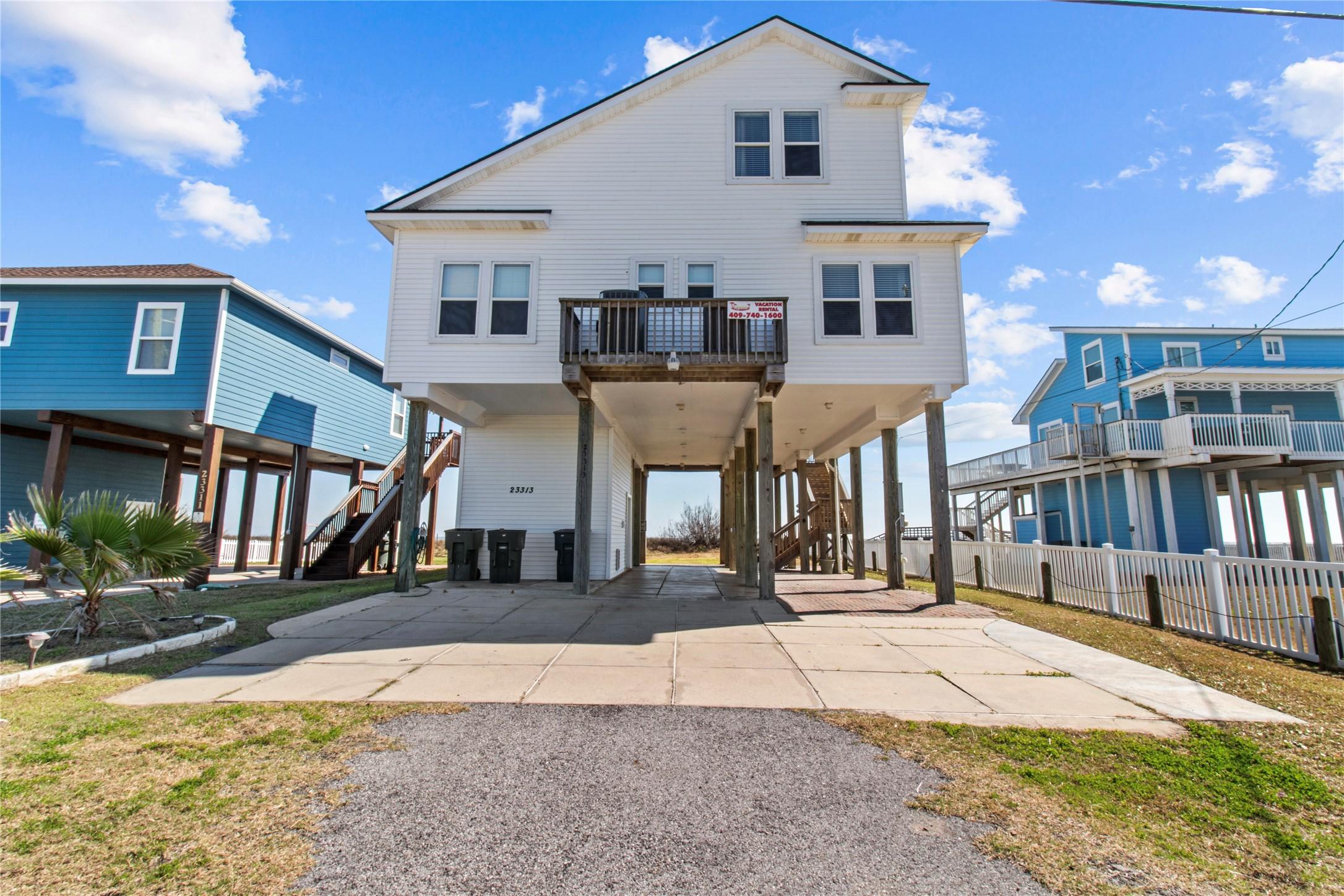 Image 3: Elevated beach house with a white exterior, featur