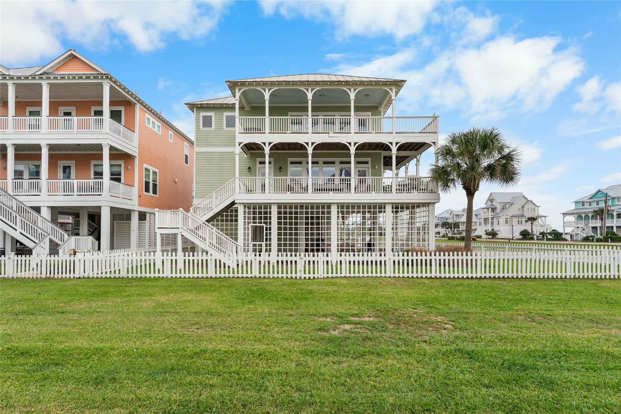Image 2: Rear exterior with double wraparound porches, fenc