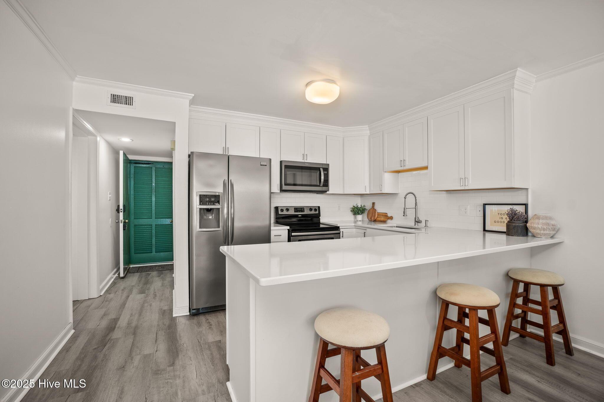 Image 4: Updated kitchen w/ peninsula seating