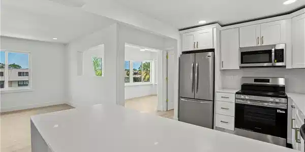 Image 4: View of the Living Room and Sun Room from the Kitc