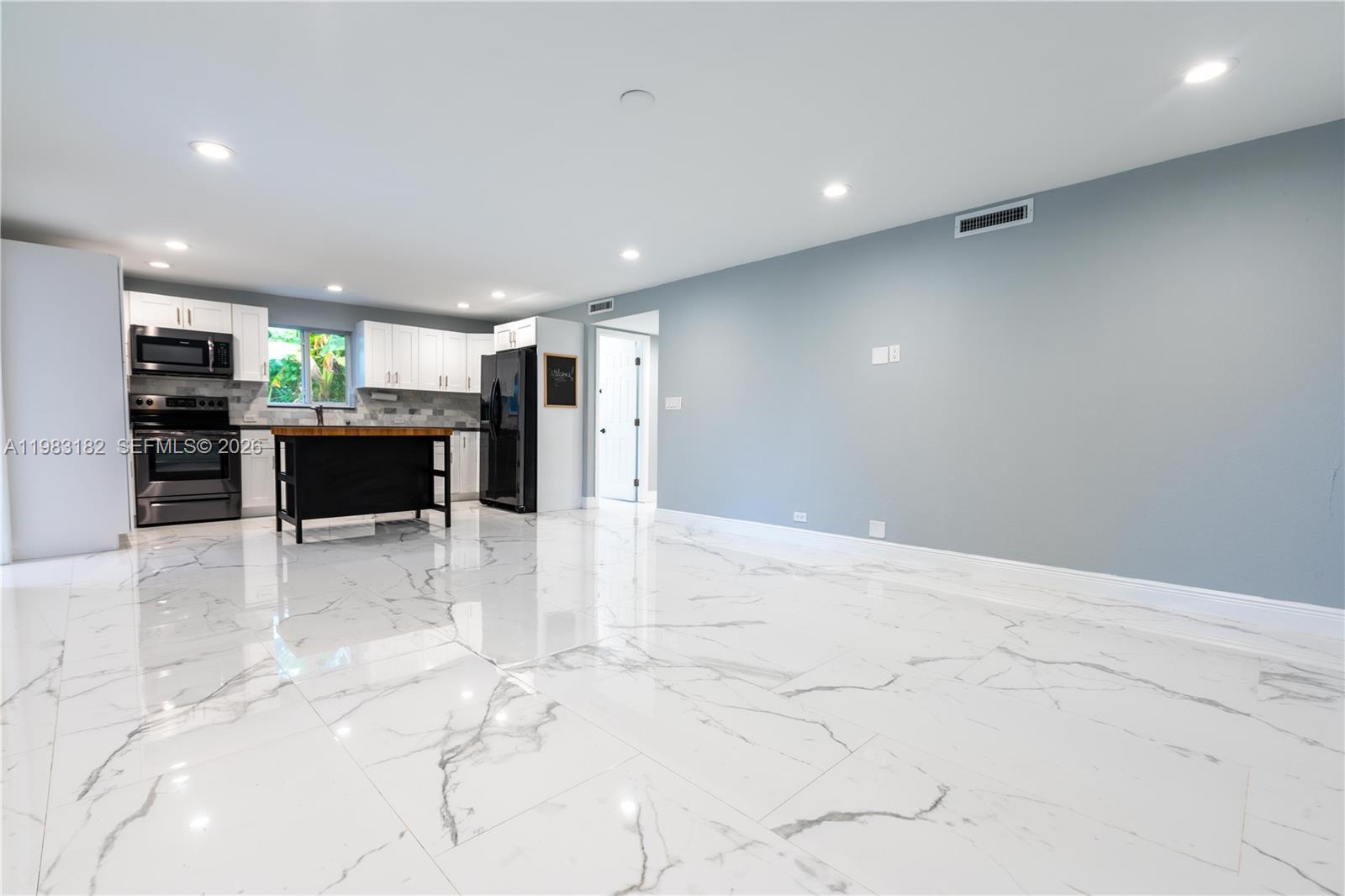 Image 2: Bright open kitchen, dining, and living area perfect for entertaining.