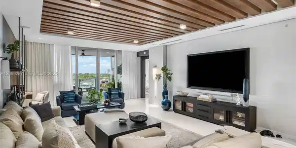 Image 4: An expansive living room offering panoramic waterfront views and seamless access to the terrace.