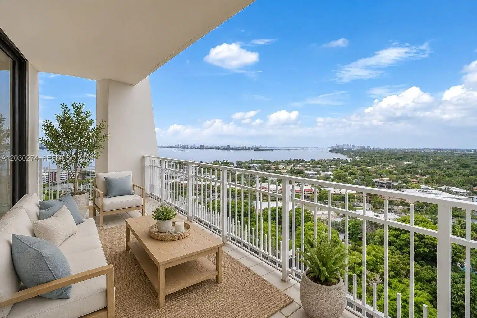 Image 1: DIGITALLY STAGED BALCONY WITH VIEWS OF MIAMI WATERWAY AND LUSH GREEN SPACE.