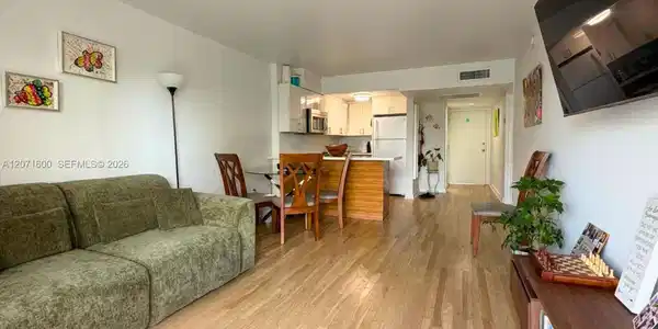 Image 2: Bright and open-concept living area featuring beautiful wood floors and seamless flow.