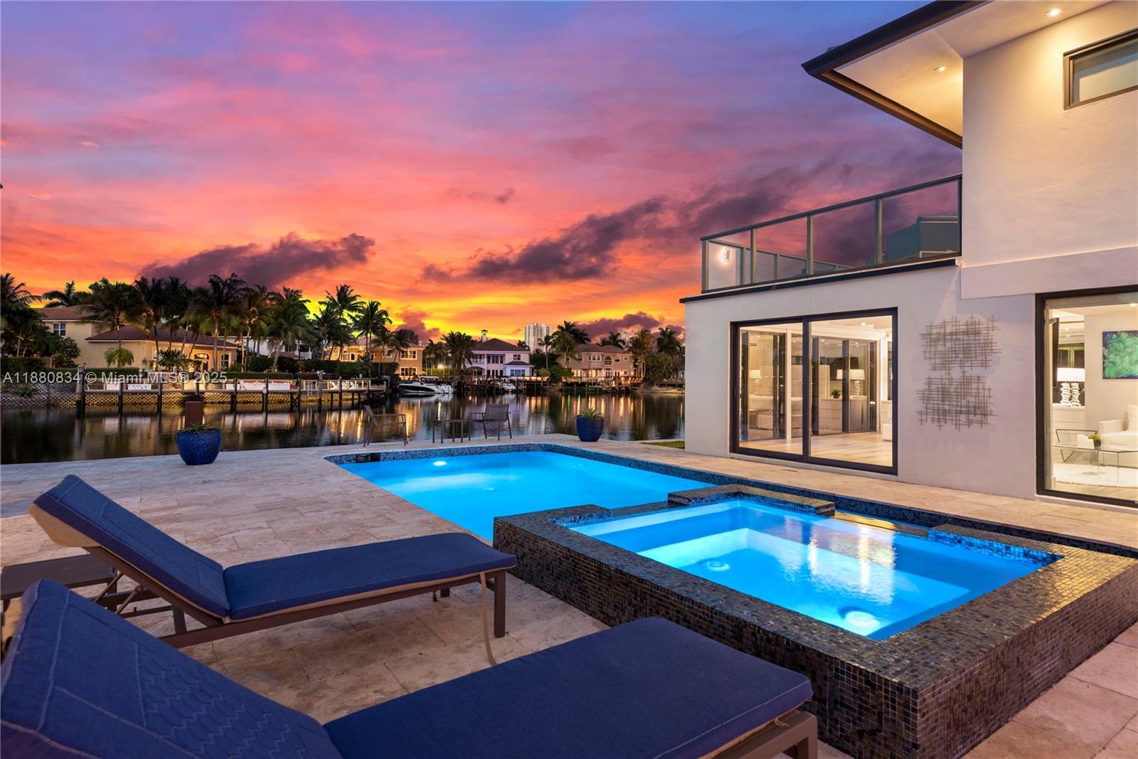 Image 2: Luxurious pool area with illuminated home at dusk.