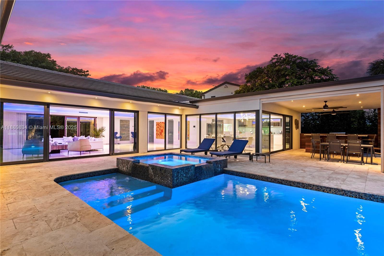 Image 3: Pool/Jacuzzi with water features with an infinity edge under a vibrant sunset.