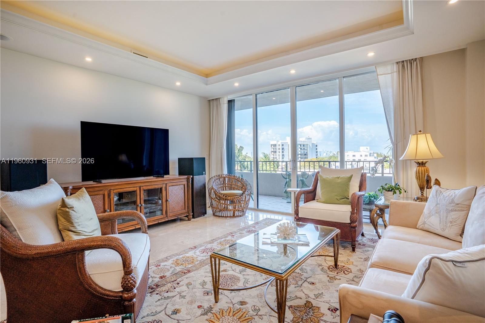 Image 2: The Living room features floor-to-ceiling glass doors that allow natural light to flood the space.