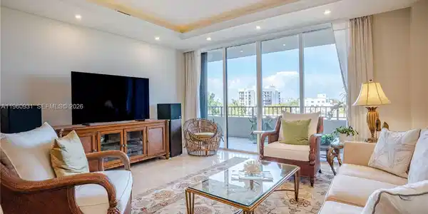 Image 2: The Living room features floor-to-ceiling glass doors that allow natural light to flood the space.