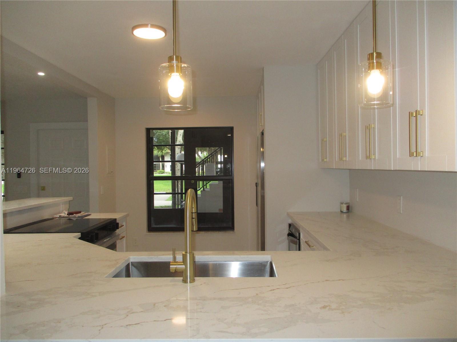 Image 3: VIEW FROM DINING AREA INTO THE KITCHEN WITH WHITE QUARTZ COUTERTOPS