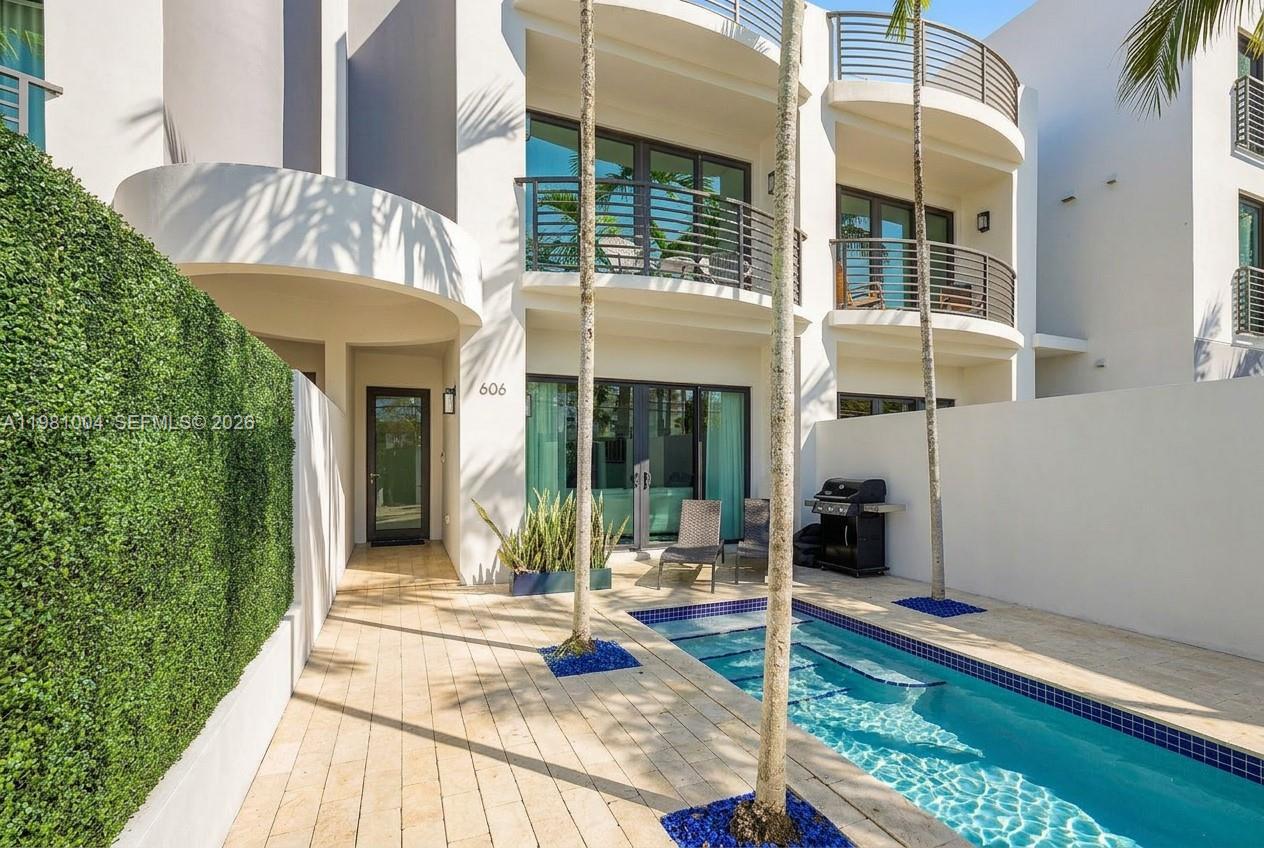 Image 1: private gated courtyard entry, lush landscaping, sparkling pool