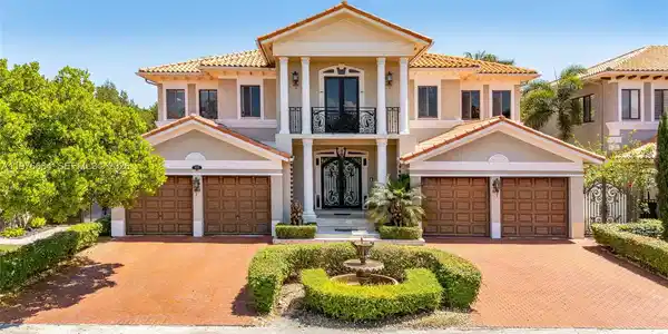 Image 3: Stunning Mediterranean-style estate boasting grand curb appeal with a symmetrical facade, soaring pi