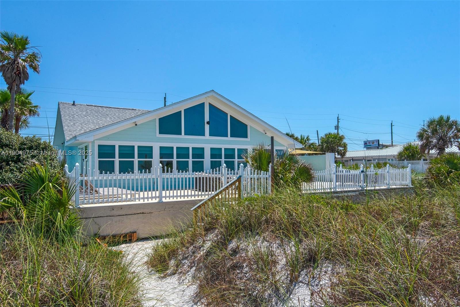 Image 3: Coastal architecture meets comfort &mdash; classic beach cottage lines with impact windows and doors
