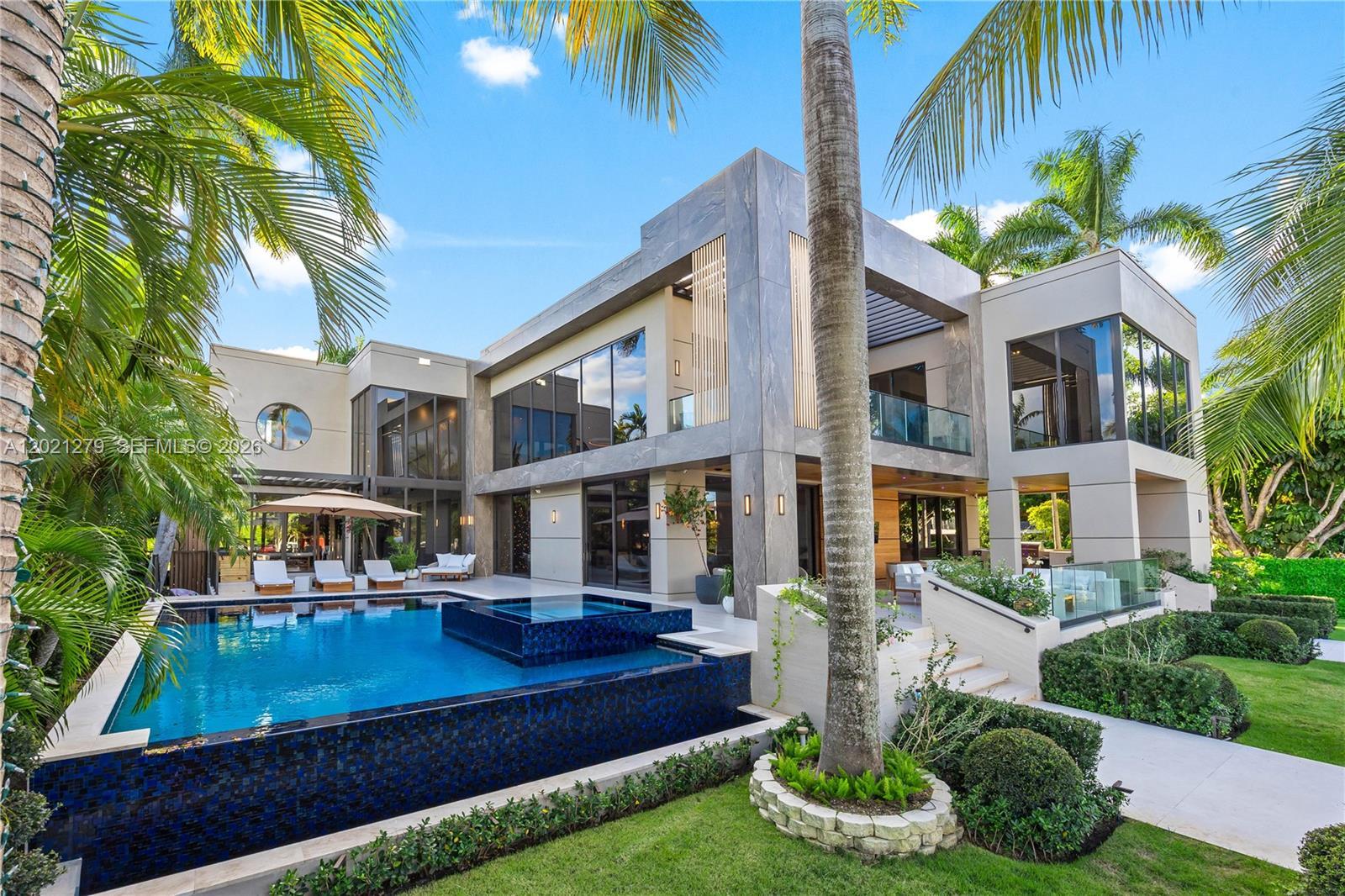 Image 1: Resort-style pool and spa with dark mosaic tile, sun deck with chaise lounges, pergola, manicured la