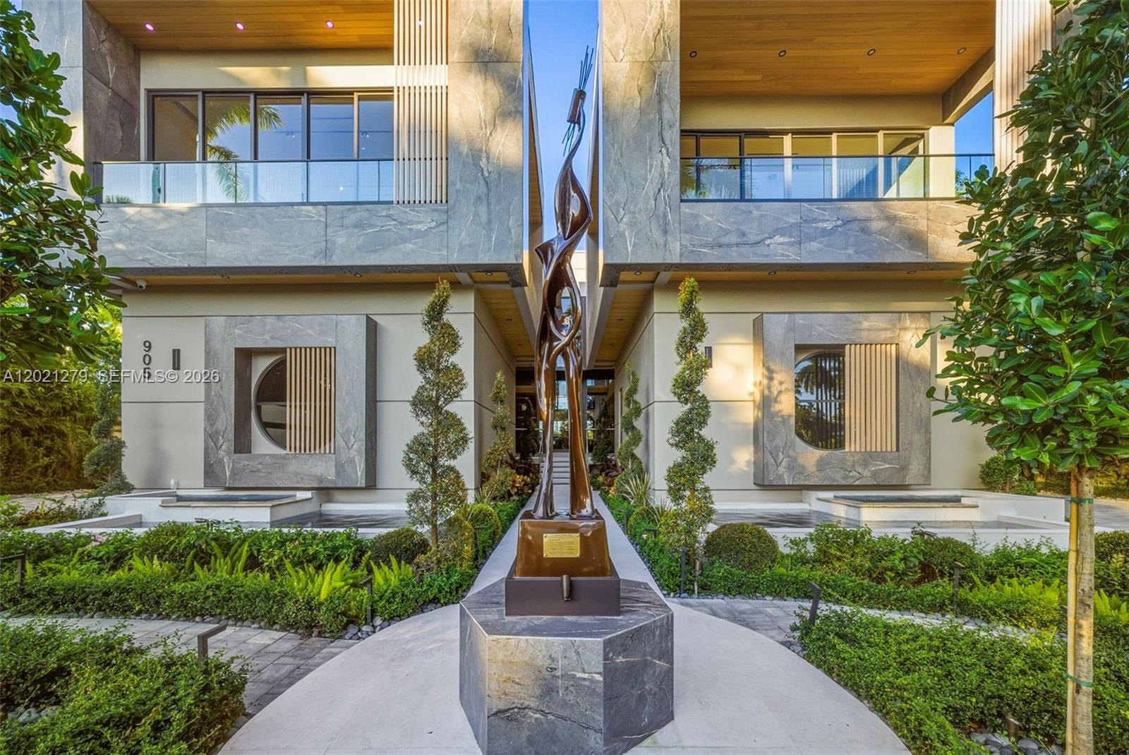 Image 4: Close-up of paver entry walkway centered on large-scale bronze figurative sculpture on stone pedesta