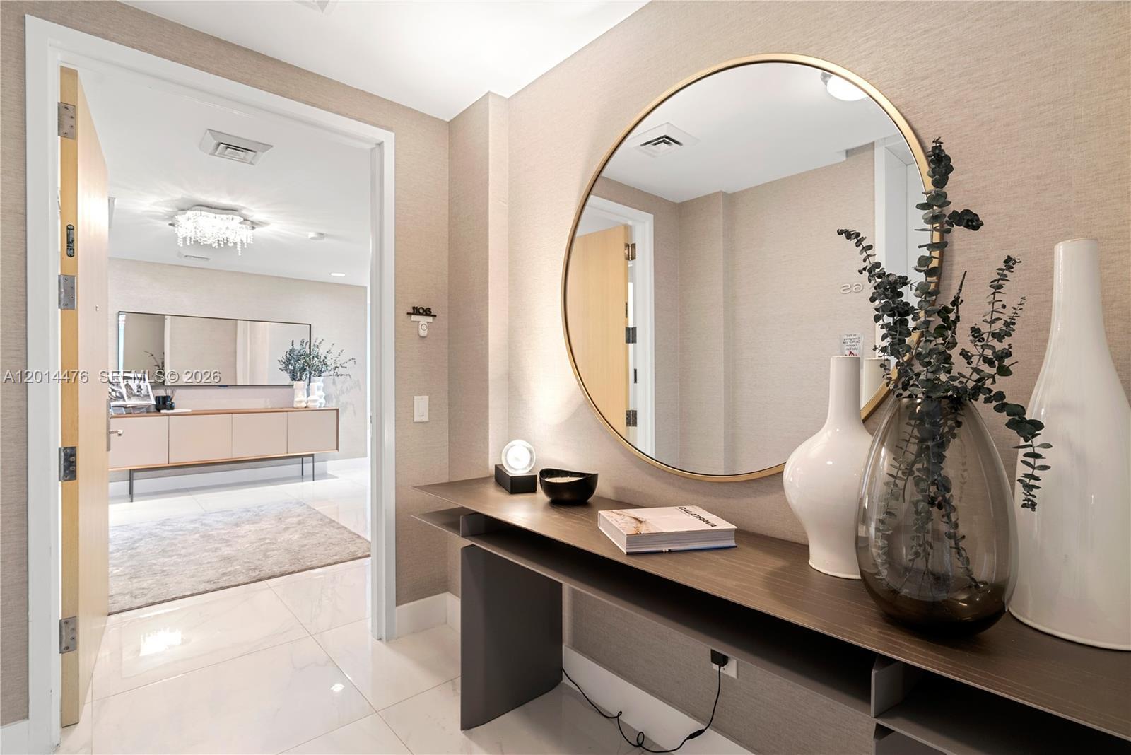 Image 2: Entry Foyer &ndash; A refined entryway sets the tone with textured wallcovering, glossy marble-look 