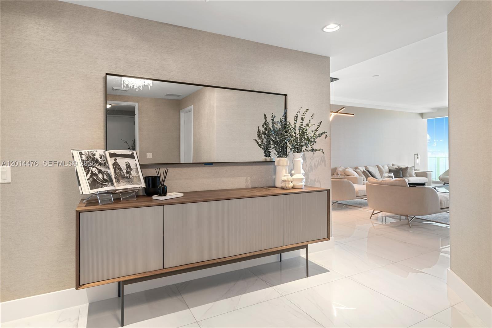 Image 3: Entry Hall &ndash; This polished hallway features a modern console, oversized mirror, and warm neutr