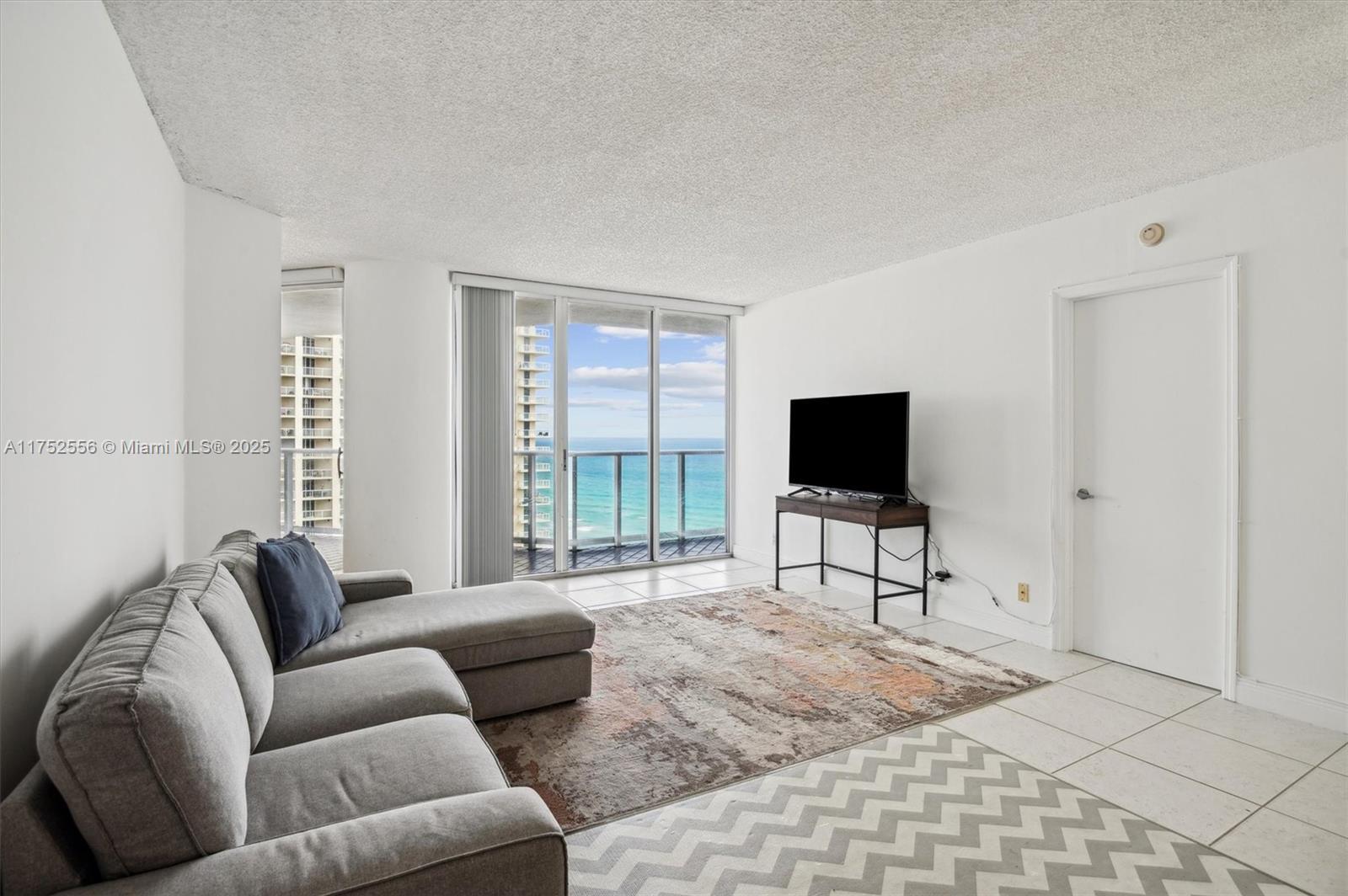 Image 3: Open Layout Living Area with Entrance to Balcony.