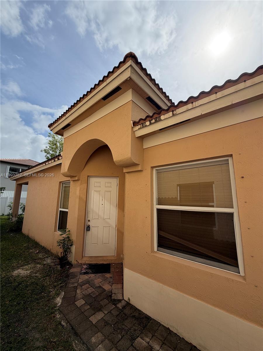 Image 2: Entry to the home is located on the side of the property. Or it can also be through the garage
