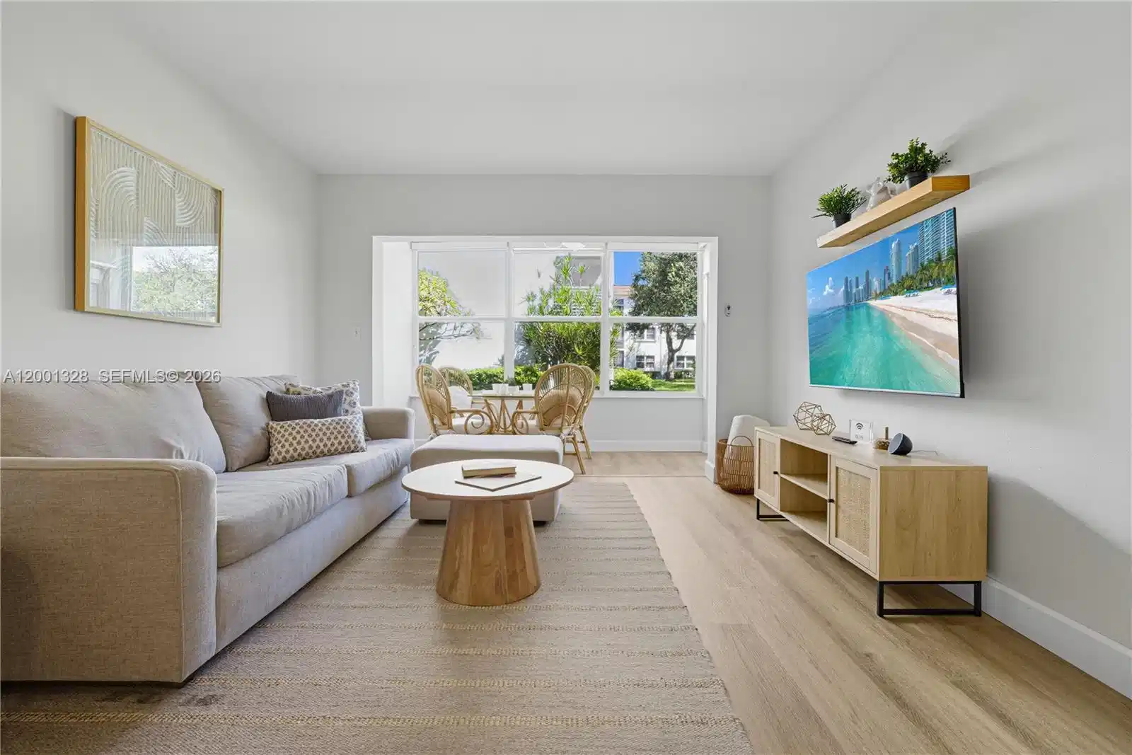 Image 1: Open concept dining and living room area, connects to the enclosed patio.
