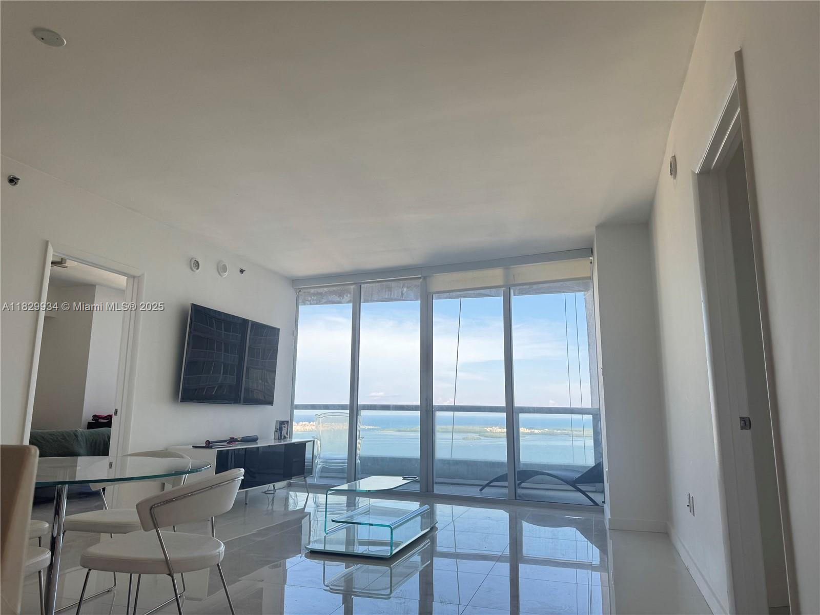 Image 3: Open-concept layout with seamless flow between living and dining spaces, polished tile flooring, and