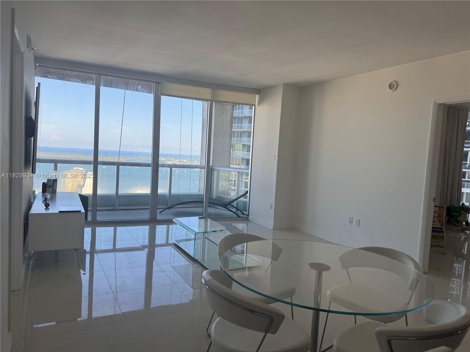 Image 4: Bright open dining area with expansive bay views, ideal for a stylish dining setup or flexible use o