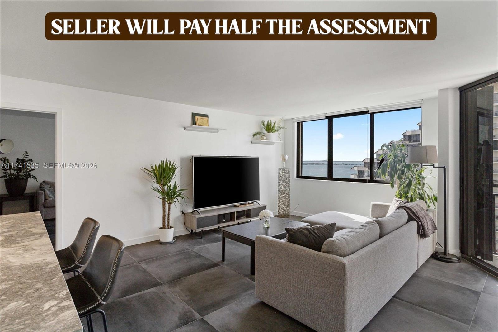 Image 2: The spacious living area seamlessly connects to a stylish kitchen with high-end finishes, making it 