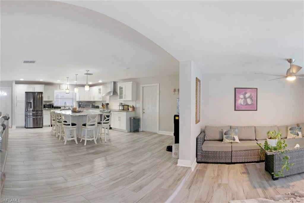 Image 3: Living room with light wood finished floors and recessed lighting
