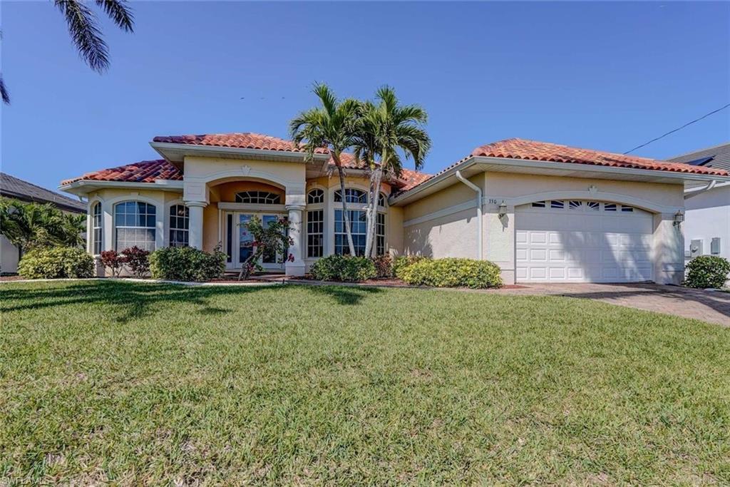Image 1: Mediterranean / spanish home featuring an attached garage, a tiled roof, a front yard, and stucco siding