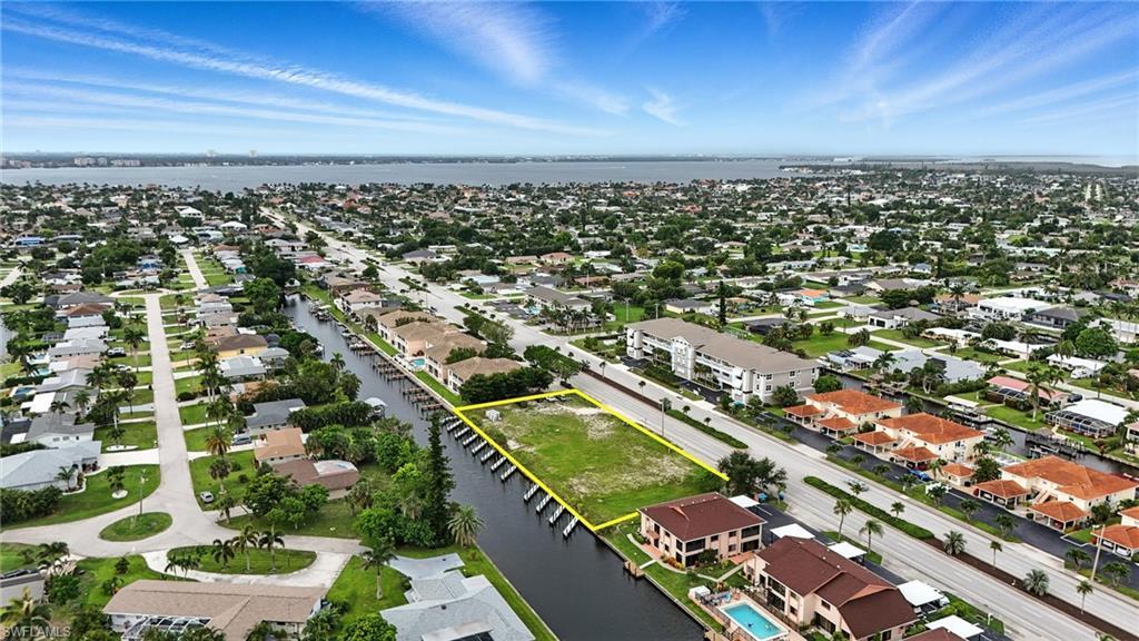 Image 4: Aerial perspective of suburban area with a nearby body of water and property parcel outlined