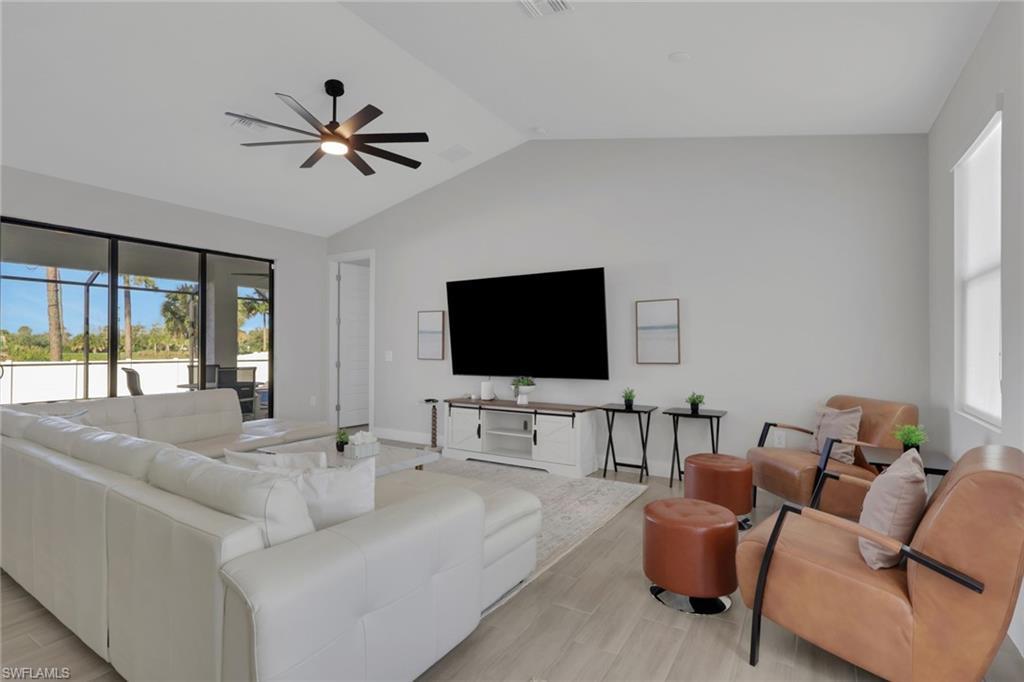 Image 4: Living room featuring wood tiled floors, vaulted ceiling, and a ceiling fan