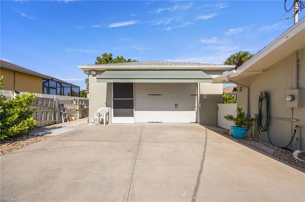 Image 3: Detached garage featuring concrete driveway