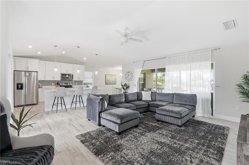 Image 3: Open-concept living space featuring wood-finish flooring