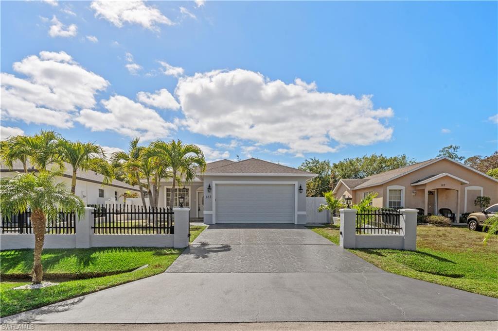 Image 1: Single story home featuring a fenced front yard with remote controlled entry gate and driveway.