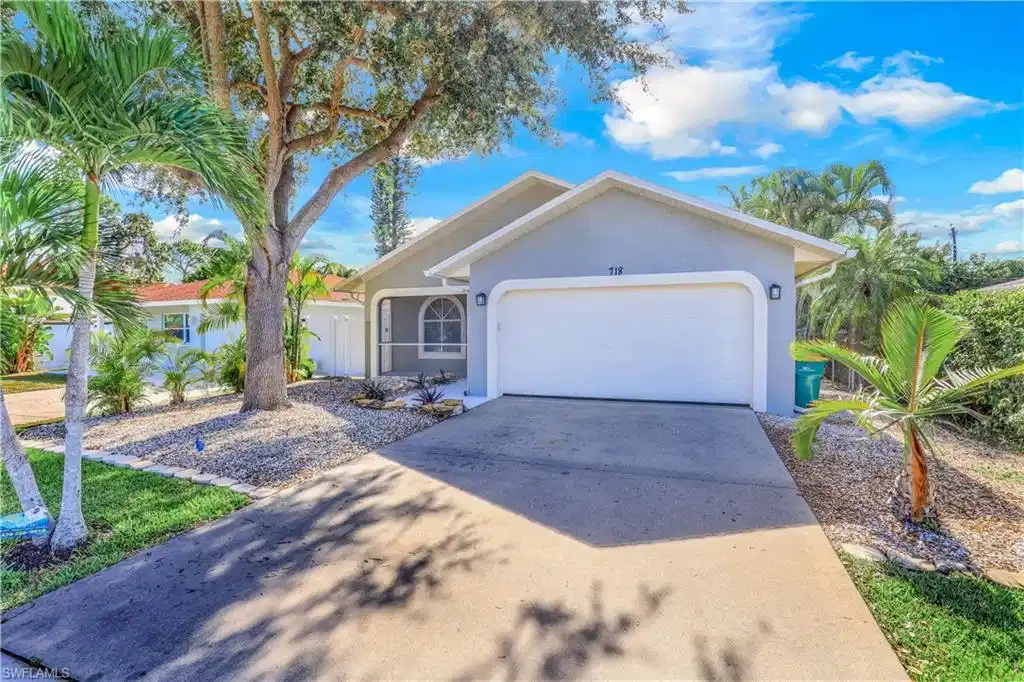 Image 1: Single story home with a garage, stucco siding, and driveway