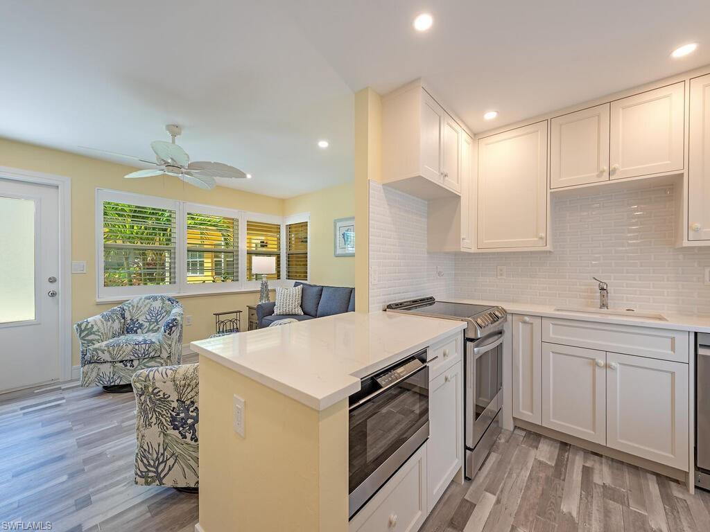 Image 3: The peninsula countertop offers an inviting space for guests to mingle and gather.