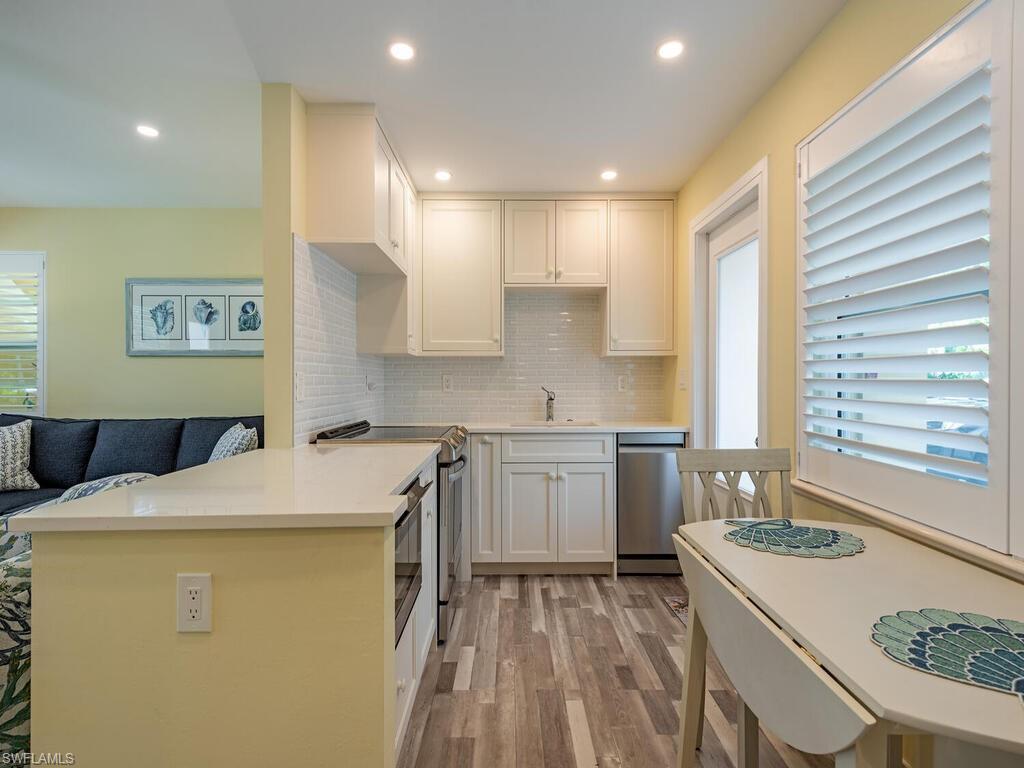 Image 4: The bright kitchen features updated flooring, appliances and cabinetry.