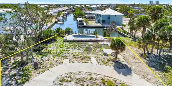 Image 2: Aerial view of property's location featuring a large body of water and property boundaries highlighted  - Virtually Edited Image