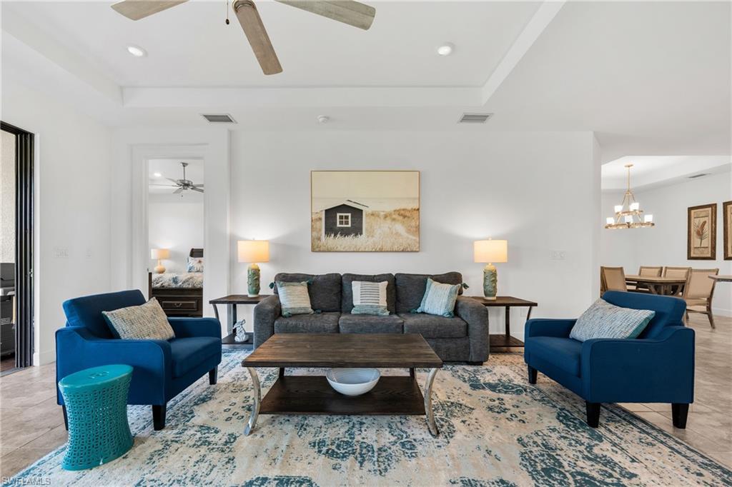 Image 4: Open-concept living space featuring a tray ceiling with a ceiling fan and recessed lighting
