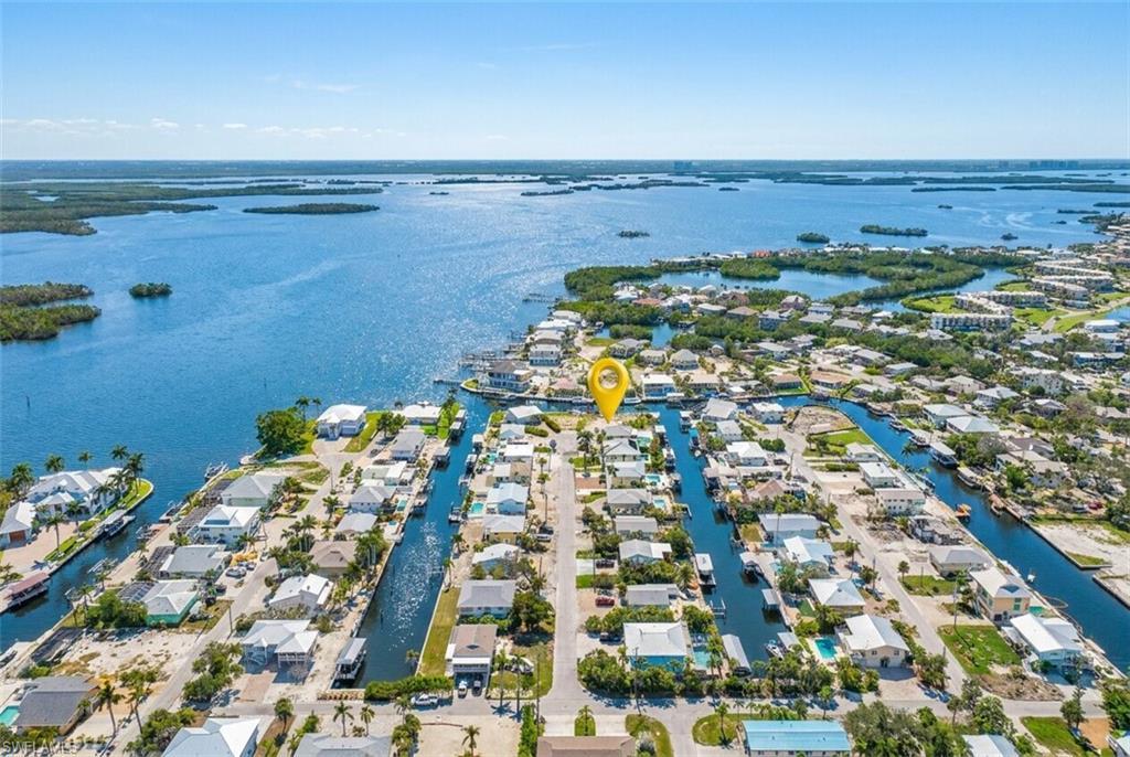 Image 2: Aerial perspective showcasing a canal-front property within a waterfront community - Virtually Edited Image