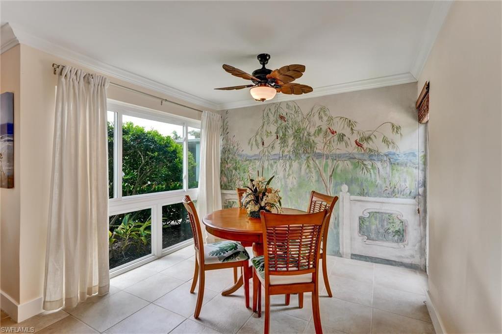 Image 3: Dining area with large floor to ceiling window on one side and another window on the courtyard side.Mural painted by a local artist about 40 years ago.