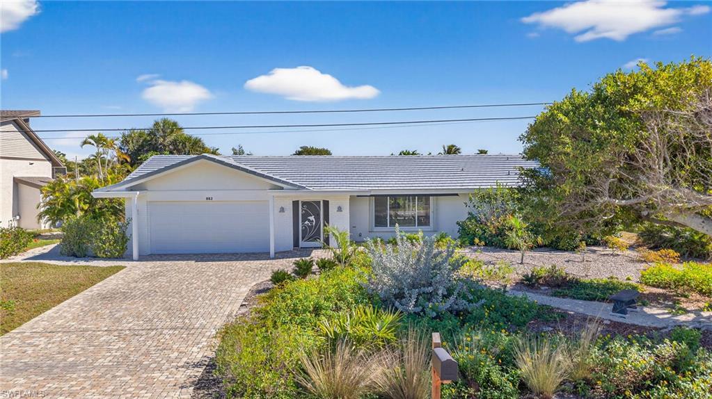 Image 1: Ranch-style home with decorative driveway, an attached garage, and stucco siding
