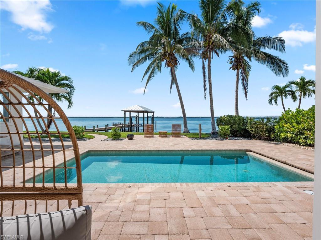 Image 3: Outdoor pool with a gazebo, a patio, and a water view