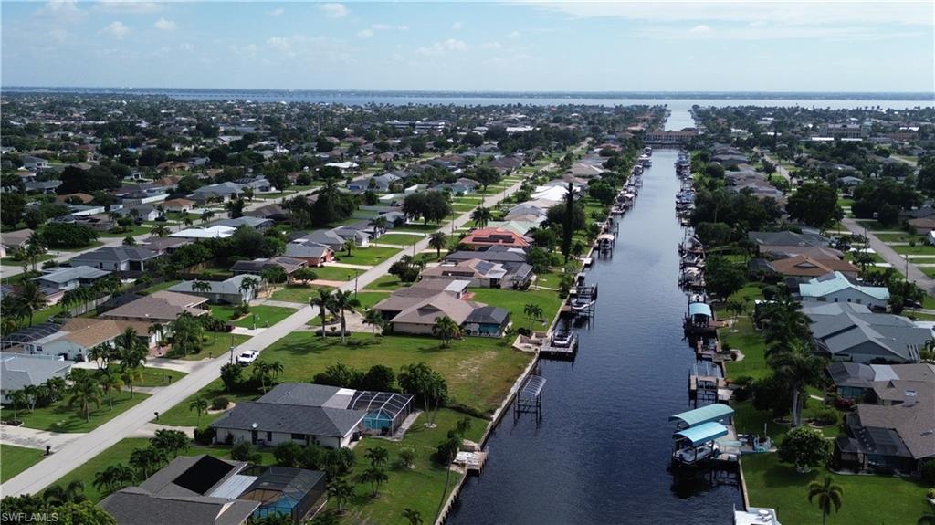 Image 2: Aerial view of property and surrounding area with a nearby body of water and nearby suburban area