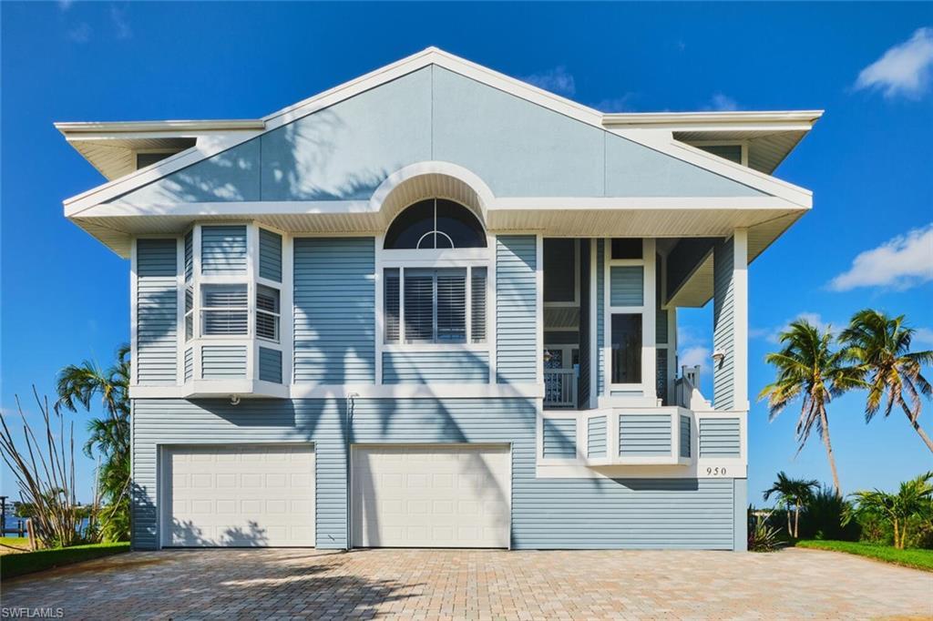 Image 2: View of front of property featuring decorative driveway, a garage, and a balcony